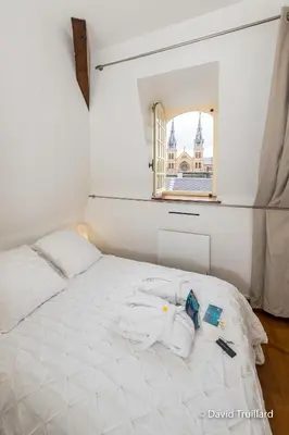 Un ou plusieurs lits dans un hébergement de l'établissement Suites Mana - Te Fiti en Plein Centre de la Place Ducale avec vue sur les toits