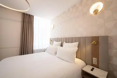 Un ou plusieurs lits dans un hébergement de l'établissement Hôtel Margaux