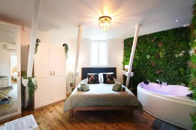 Un ou plusieurs lits dans un hébergement de l'établissement Jungle Évasion, Épernay - Jacuzzi & Sauna