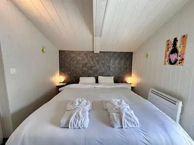 Un ou plusieurs lits dans un hébergement de l'établissement Cottage Le Rosie au bord du lac avec jacuzzi