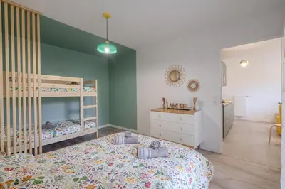 Un ou plusieurs lits dans un hébergement de l'établissement T2 familial avec jardin, calme à 15 min de Disney