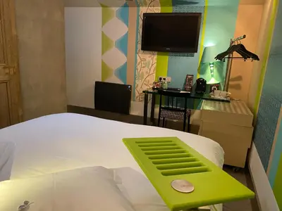 Un ou plusieurs lits dans un hébergement de l'établissement Hôtel Le Dormeur du Val