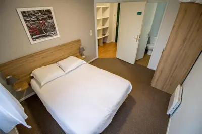 Un ou plusieurs lits dans un hébergement de l'établissement KOSY Appart'hôtel Le Champ De Mars Reims