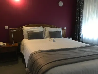 Un ou plusieurs lits dans un hébergement de l'établissement Logis Hotel & Restaurant La Paix