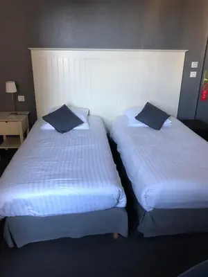 Un ou plusieurs lits dans un hébergement de l'établissement Logis - Hôtel du Nord et Restaurant La Table d'Elisa