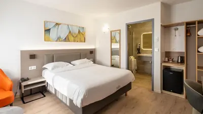 Un ou plusieurs lits dans un hébergement de l'établissement Hotel Tambourin