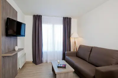 Télévision ou salle de divertissement dans l'établissement Séjours & Affaires Reims Clairmarais
