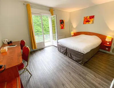 Un ou plusieurs lits dans un hébergement de l'établissement Logis Hôtel - Restaurant Le Tulipier